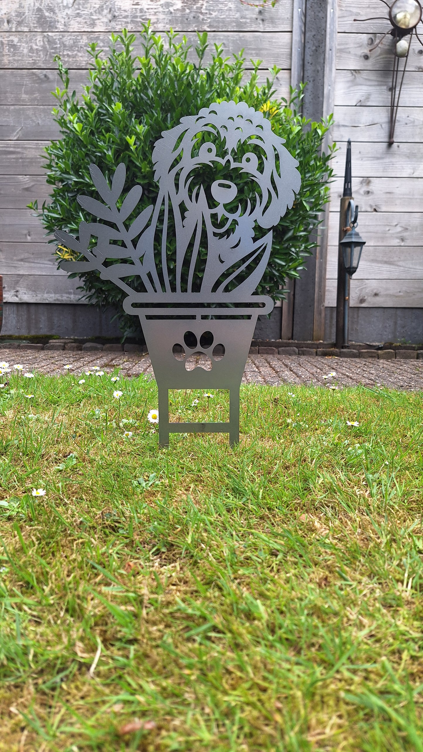 Vrolijke honden tuinprikker Boefje in de Bloempot, gemaakt van cortenstaal, ideaal voor bloemperken en tuinaccessoires.